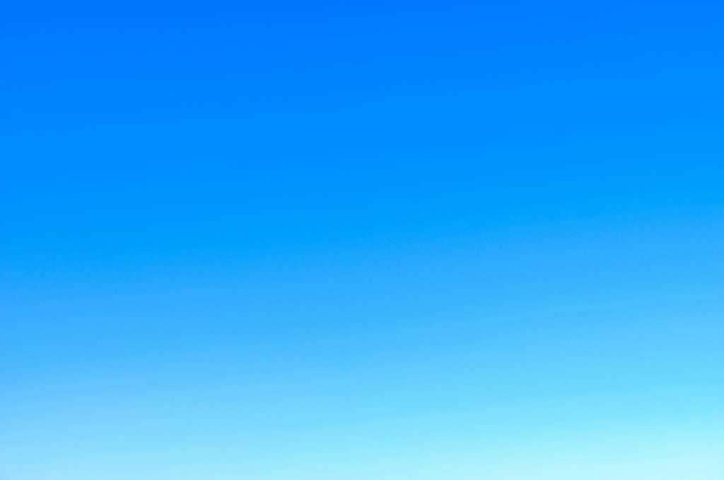 A serene view of a vibrant clear blue sky with a subtle gradient, perfect for backgrounds.