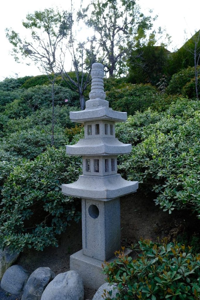 a stone pagoda in the middle of a garden