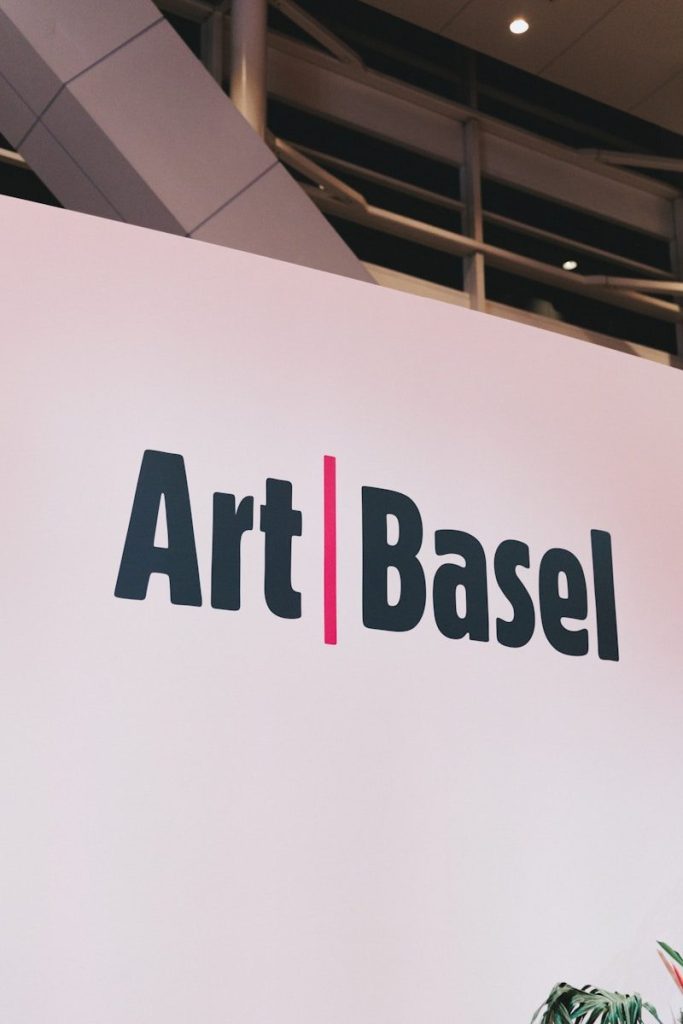Art basel logo on a white wall.