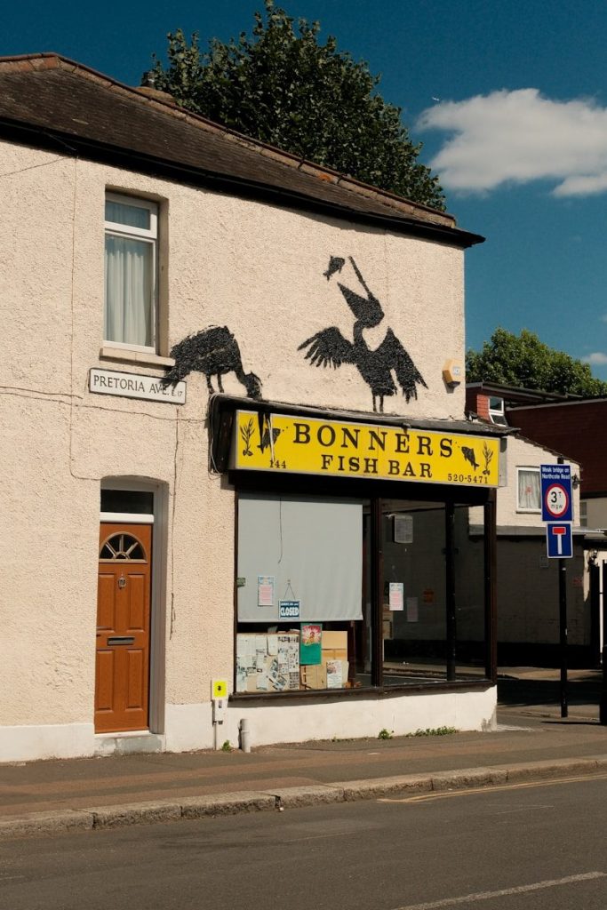 A white building with a yellow sign on the front of it